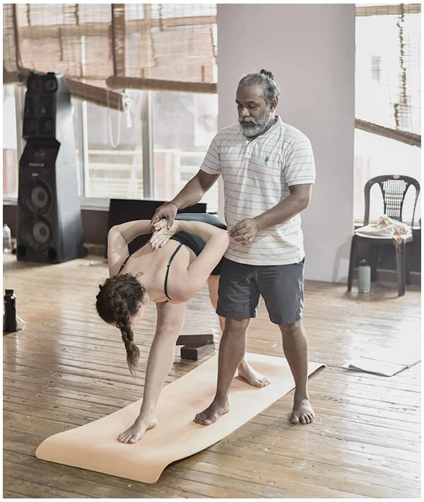 Yoga instructor assisting student